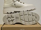 pair of white boots sitting on top of a box on top of a table