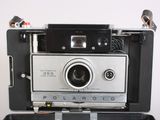 an old polaroid camera sitting on top of a suitcase