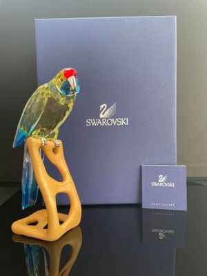 une figurine représentant un perroquet perché sur une table