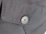 close up of a button on the back of a gray jacket