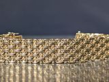 a close up of a gold chain bracelet on a table