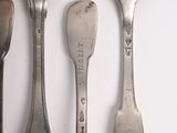 four spoons and a spoon rest on a white surface