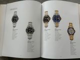 un livre ouvert sur lequel sont posées plusieurs montres différentes