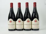 quatre bouteilles de vin sont alignées sur une surface blanche