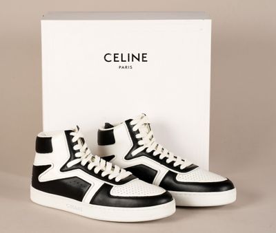 une paire de baskets noires et blanches devant une boîte blanche