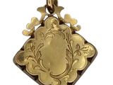 an image of a gold pendant with a picture of a bird on it