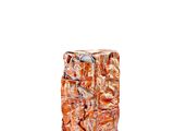 un gros morceau de marbre orange posé sur une surface blanche
