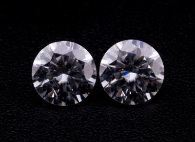une paire de diamants taille ronde sur un fond noir