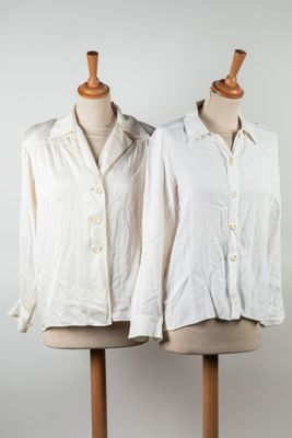 two mannequins with white shirts on them on a wooden stand
