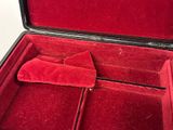 a red velvet case with a pair of shoes inside of it