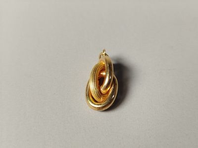 gros plan d'un pendentif plaqué or sur une surface blanche