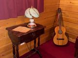 a small table with a lamp and a guitar in the corner