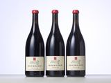 three bottles of red wine sitting on top of a table