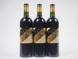 trois bouteilles de vin rouge posées sur une table blanche