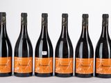 six bouteilles de vin sont alignées sur une table