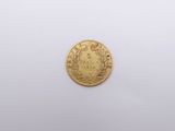 a close up of a gold coin on a white surface