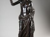 une statue en bronze représentant une femme tenant une pomme à la main