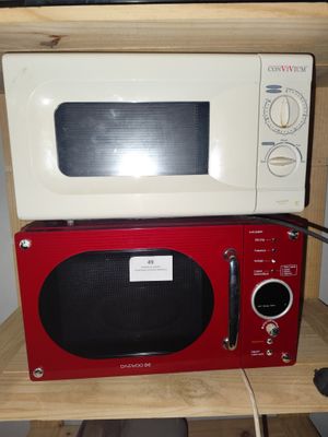 un micro-ondes rouge posé sur une étagère en bois