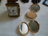 a clock, mirror, gloves, and a pair of gloves on a table
