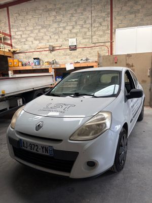 a picture of a car in a garage with a truck in the background