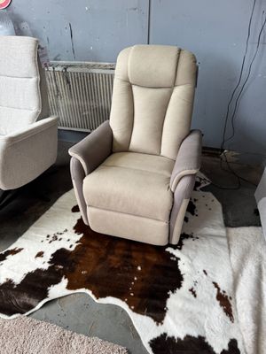 deux fauteuils inclinables dans une pièce où se trouve un tapis en peau de vache