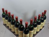 bottles of wine are lined up in a wooden holder