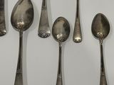 five spoons and two spoon spoons on a white surface