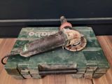 a green tool box with a sander on top of it