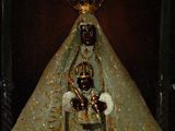 painting of a statue of the virgin of guadalupe surrounded by a group of people
