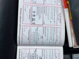 a book with a pen and a calculator on the seat of a car