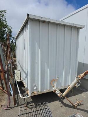 un conteneur blanc posé contre le mur d'un immeuble