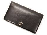 un portefeuille Chanel en cuir noir orné d'un logo CC argenté sur le devant