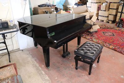 a piano and a stool in a room with a lot of furniture