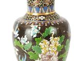 un vase sur lequel sont peintes des fleurs sur fond blanc