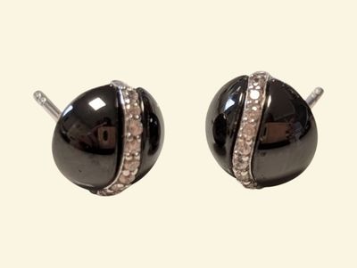 pair of black and white stud earrings with crystals on them