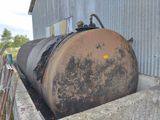 a large metal tank sitting in the middle of a cement wall