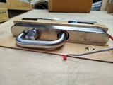 a metal latch on a piece of cardboard on a table