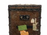 an old suitcase with stickers on it sitting on a white surface