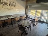 l'intérieur d'un restaurant avec des tables et des chaises, ainsi qu'une enseigne sur laquelle on peut lire « Darius Burger »