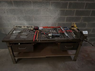 a workbench with many tools on it in a room