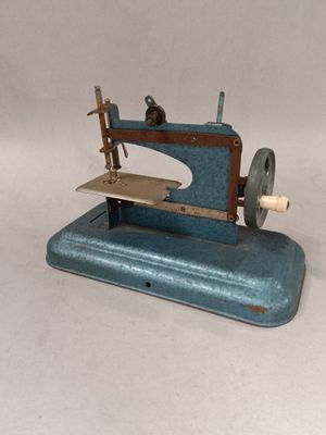 a blue sewing machine sitting on a white surface