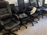 plusieurs chaises de bureau noires alignées dans une pièce dotée d'une fenêtre