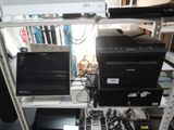 deux ordinateurs de bureau et un ordinateur portable posés sur une étagère dans une pièce