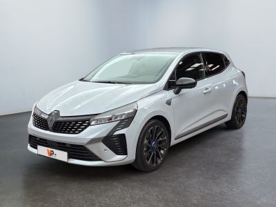Une voiture blanche est garée dans une pièce au sol noir.
