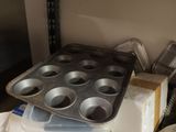 a muffin pan on a shelf in a kitchen next to a cupcake pan