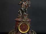 une horloge surmontée d'une statue, posée sur une table