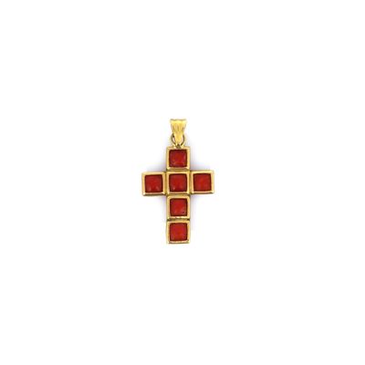 un pendentif en forme de croix en or, orné de pierres rouges sur fond blanc