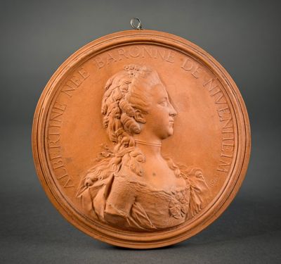 a close up of a bronze medallion with a woman ' s face
