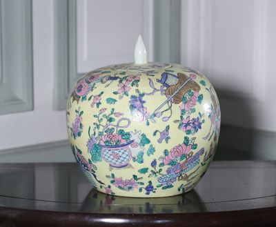 un vase posé sur une table, sur lequel se trouve un autre vase