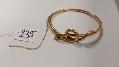 un gros plan d'un bracelet en or muni d'une chaîne, posé sur une table